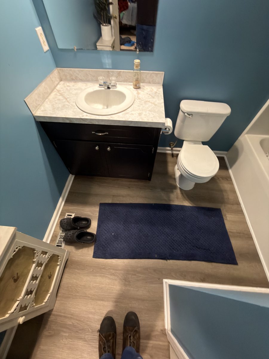 Finished bathroom LVP flooring with white trim