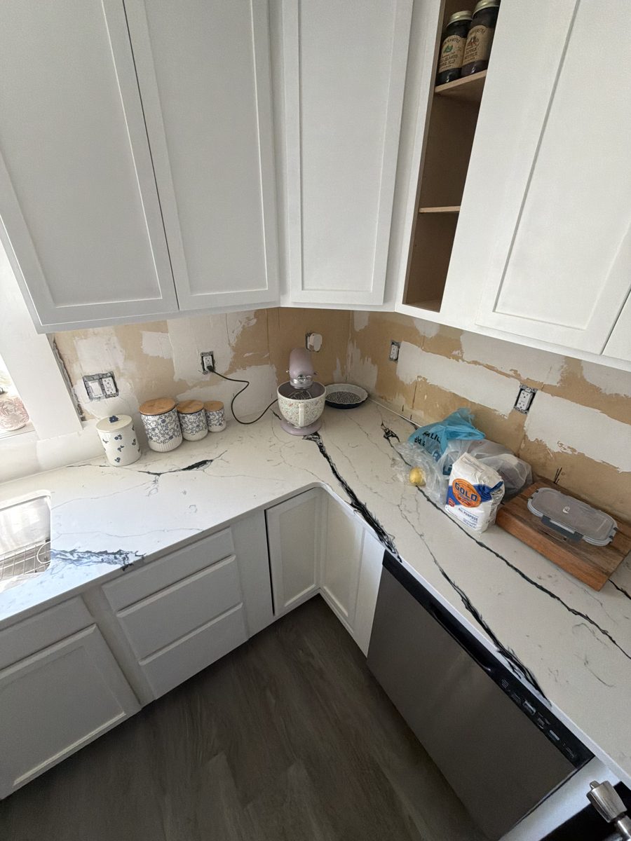 Finished kitchen area with gray LVP flooring and white cabinets