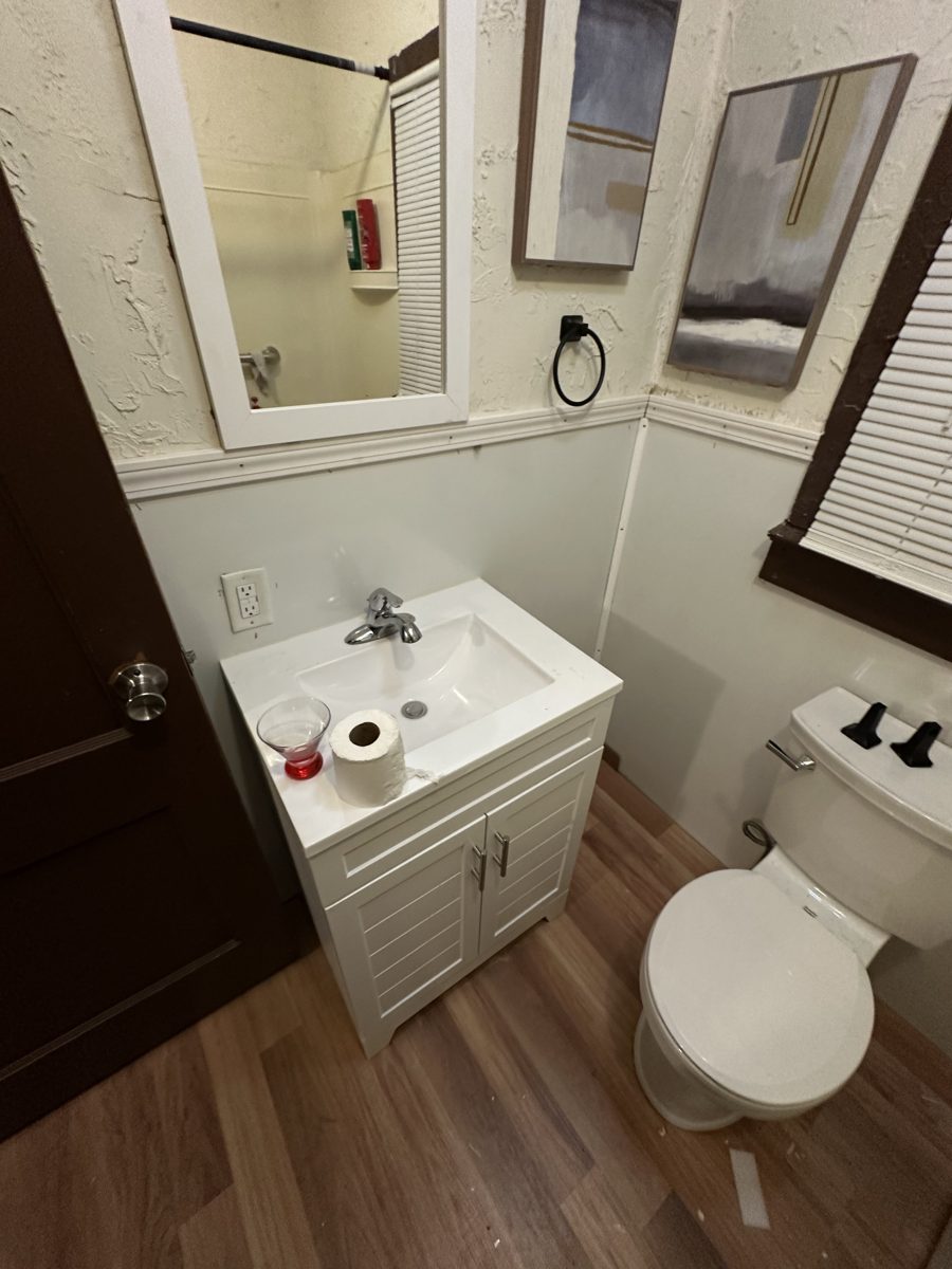 Bathroom vanity area with new flooring and plumbing work